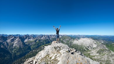Hiker stretches arms into the air