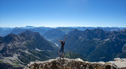 Hiker stretches arms into the air