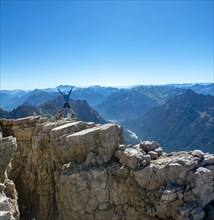 Hiker jumps and stretches arms into the air