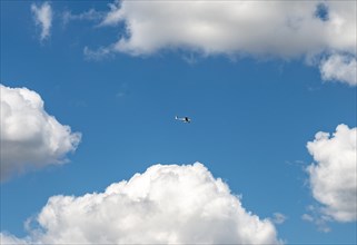 Electric airplane flying in front of a blue cloudy sky