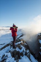 Woman standing at divergent tectonic boundary between North American and Eurasian plates