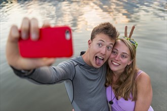 Young couple photographing themselves with mobile phone
