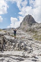 Hiker stretches arms into the air