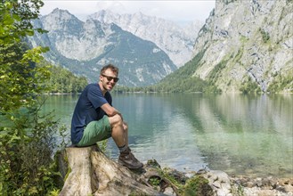 Young hiker sitting on the shore of the Obersee