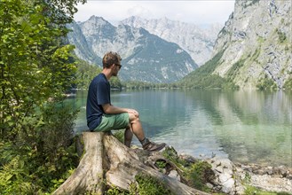 Young hiker sitting on the shore of the Obersee