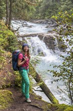 Female hiker on trail along a wild river