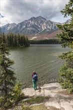 Female hiker stands on the lakeshore