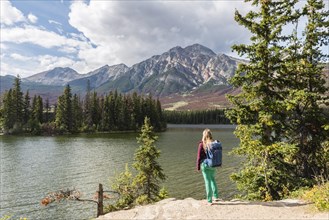 Female hiker stands on the lakeshore