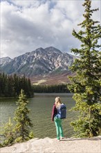 Female hiker stands on the lakeshore
