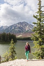 Female hiker stands on the lakeshore