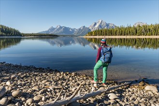 Young woman with rucksack standing on shore