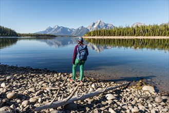 Young woman with rucksack standing on shore