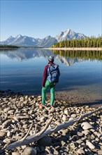 Young woman with rucksack standing on shore