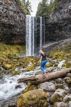 Young woman crosses river