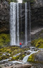 Hiker in front of a high waterfall