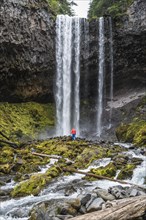 Hiker in front of a high waterfall