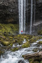 Hiker in front of a high waterfall