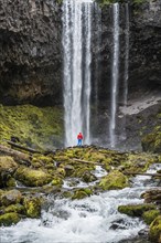 Hiker in front of a high waterfall