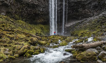 Hiker in front of a high waterfall