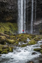 Hiker in front of a high waterfall