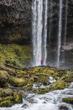 Hiker in front of a high waterfall