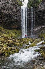 Hiker in front of a high waterfall