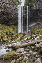 Hiker in front of a high waterfall