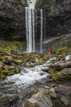 Hiker in front of a high waterfall