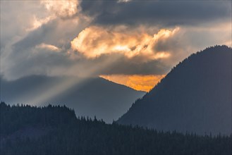 Hilly wooded mountain landscape at sunset with dramatic clouds