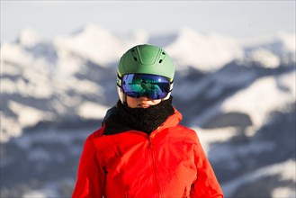 Female skier with ski helmet and ski goggles looks into the camera