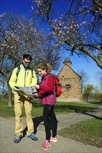 Hikers read map in front of the Nikolauskapelle