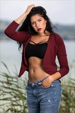 Portrait of a young woman with a wine red jacket and blue jeans