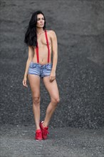 Woman with jeans hotpants and red suspenders