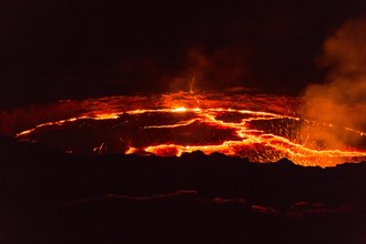 Glowing lava lake with eruptions at night