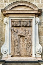 Grave stone of the monastery founders Adalbert and Otkar above the portal of the basilica of St. Quirin