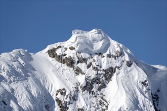 Massive snow cornice on a mountain peak