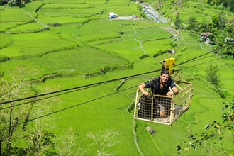 Man in a cargo seat above Hapao rice terraces
