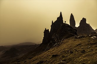 Rock Old Man of Storr backlit with photographer on rock