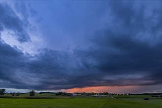 Thunderstorm sky with small village and meadows landscape