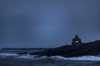 Small house on coast at blue hour
