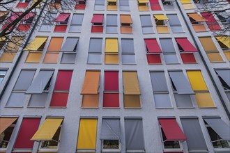 Facade of a residential building with colourful roller blinds