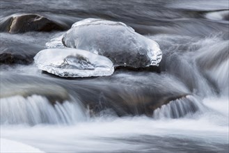 Mountain stream with ice in winter