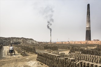 Stack of bricks with burning towers in a brickyard