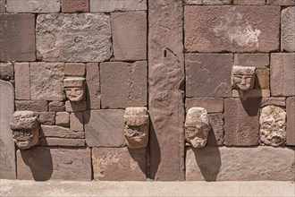 Stone heads in wall of Kalasasaya temple (place of standing stones) with monoliths from pre-Inca period