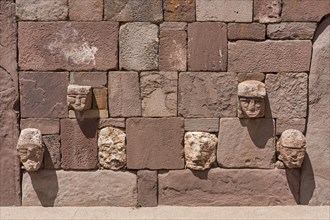 Stone heads in wall of Kalasasaya temple (place of standing stones) with monoliths from pre-Inca period