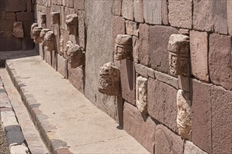 Stone heads in wall of Kalasasaya temple (place of standing stones) with monoliths from pre-Inca period