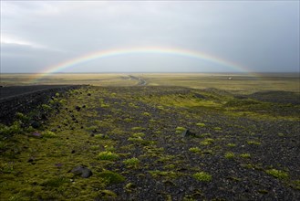 Rainbow over flat volcanic landscape near Braidarmerkursandur