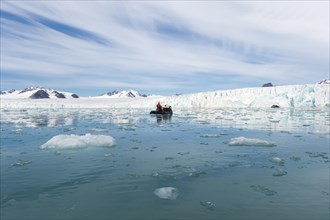 Zodiac boat with tourists navigating in front of Lilliehook glacier