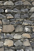 Wall of layered ground-down basalt stones and slates