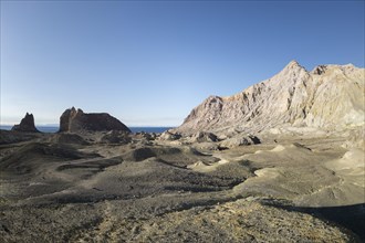 Rock formations on the volcanic island of White Island with shadows of two people
